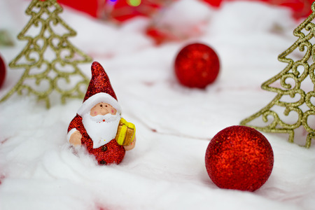 Santa Claus figurine with gift on red backgroundの写真素材