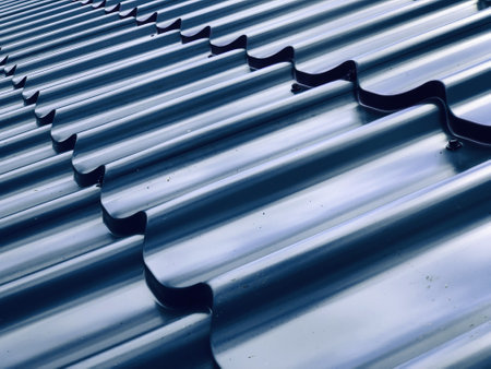A sheet of blue profile metal tile lies on the roof of a mansard roofの写真素材