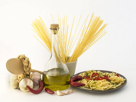 Plate of spaghetti with garlic, olive oil, chili pepper on white backgroundの写真素材