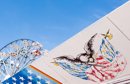Symbols of the USA flag. In the background a Ferris wheel and the skyの写真素材