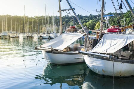 Fishing boats in the port of Sistiana, Trieste, Italy at sunsetの写真素材