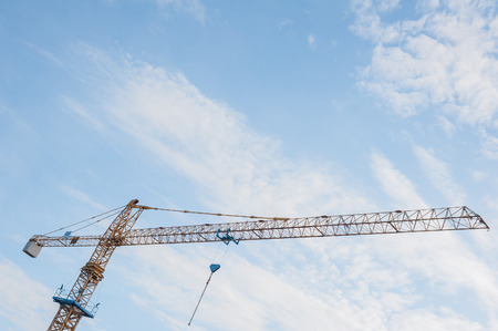 Yellow crane and blue sky on building siteの写真素材