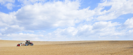 Farm work. Tractor compresses the soil after planting with rollers.のeditorial素材