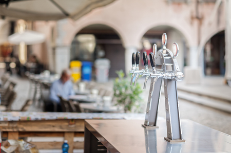 Draught beer taps and other beverages in a bar.の写真素材