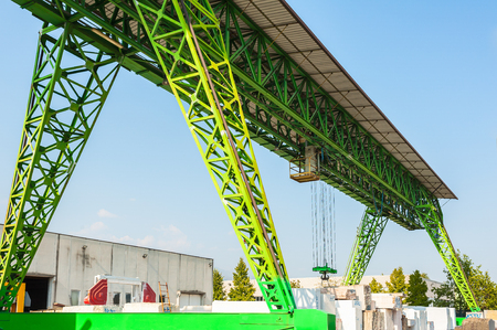 Green gantry crane at work in a warehouse of marble blocksの写真素材