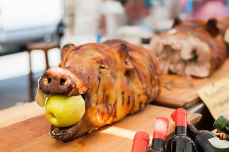 Pork roasted with apple in the mouth. Typical porchetta Italiana. Exposure to market.の写真素材