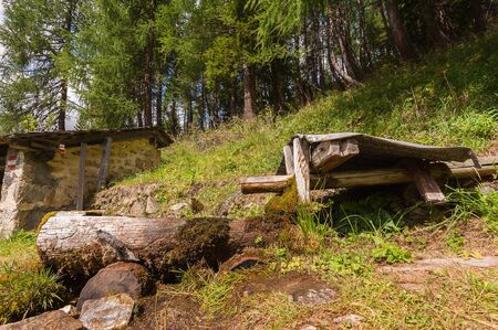 Old wooden fountain in the mountain and forest in background. Photo in vintage style.の写真素材
