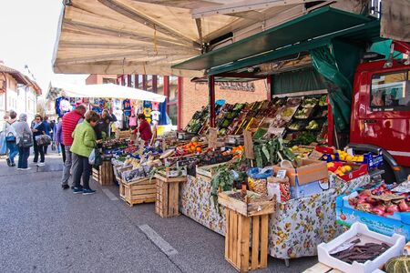 Udine, Italy - April 2 2019 :People at the local traditional outdoor market. Vegetable and fruit stand.のeditorial素材