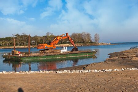 Excavator for channel dredge on a barge.の写真素材