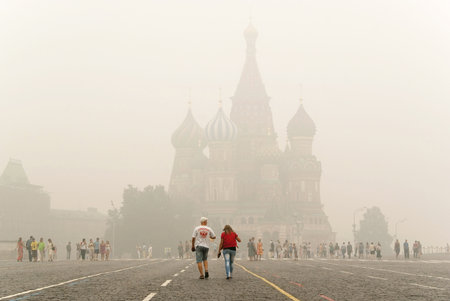 Unidentified tourists go to Intercession Cathedral  St  Basil s  on the Red Square under smog on august 7, 2010 in Moscow  City covered an unprecedented smoke from burning forests のeditorial素材