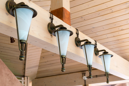 Retro lanterns mounted on a wooden building interiorの写真素材