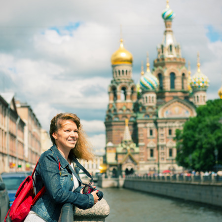 Young female tourist near the Church of Savior on Spilled Blood (Cathedral of the Resurrection of Christ) in Saint Petersburg, Russiaの写真素材