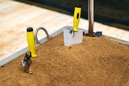 Trowel tool in the sand - ceremony of the start of construction.の写真素材