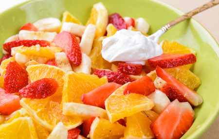 Fruit salad with strawberries, oranges, bananas and sour creamの写真素材