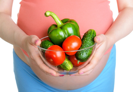 Pregnant woman with fresh vegetables isolated on white backgroundの写真素材