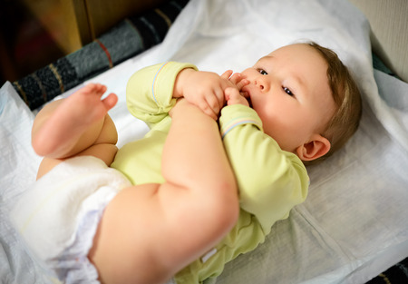 Baby hugged his leg and sucking toe