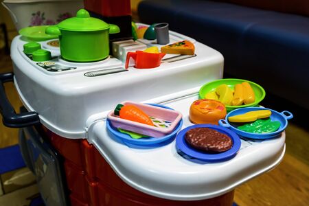 Children's toy kitchen with toy food in playroom