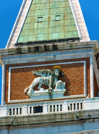 Top of the St Mark's Campanile with sculpture of the lion at the Piazza San Marco in Venice, Italy. The lion is the symbol of Venice.の写真素材