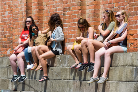 Venice, Italy - May 19, 2017: Female tourists are resting by the Campanile in the Piazza San Marco (St. Mark's Square) on a hot summer day. This is the main square of Venice.のeditorial素材