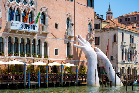 Venice, Italy - May 18, 2017: Giant hands rise from the water of the Grand Canal to support the building. This powerful report on climate change from the artist Lorenzo Quinn.のeditorial素材