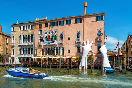 Venice, Italy - May 18, 2017: Giant hands rise from the water of the Grand Canal to support the building. This powerful report on climate change from the artist Lorenzo Quinn.のeditorial素材