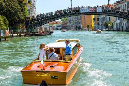 Venice, Italy - May 18, 2017: Water taxi with tourists sails along the Grand Canal in Venice. Motor boats are the main transport in Venice. Romantic water trip across Venice in summer.のeditorial素材