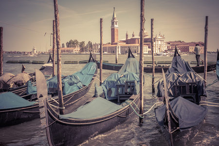 Old berth with gondolas near San Marco Square, Venice, Italy. Venetian lagoon. Gondola is a traditional romantic transport in Venice. Romantic water trip in Venice. Vintage photo of Venice in summer.の写真素材