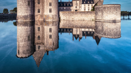 Castle or chateau de Sully-sur-Loire in evening, France. This medieval castle is a landmark of Europe. Panorama of old French castle with reflection in the water. View of the vintage castle at dusk.のeditorial素材
