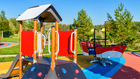 Colorful playground with slide in a city park. Empty beautiful outdoor playground in summer. Modern urban place for kids games and sport. Scenic view of children ground.の写真素材