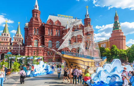 Moscow â May 19, 2019: People walk on Manezhnaya Square by Moscow Kremlin, Russia. This place is a tourist attraction of Moscow. Festive decorations near landmarks in the Moscow city center in summer.のeditorial素材