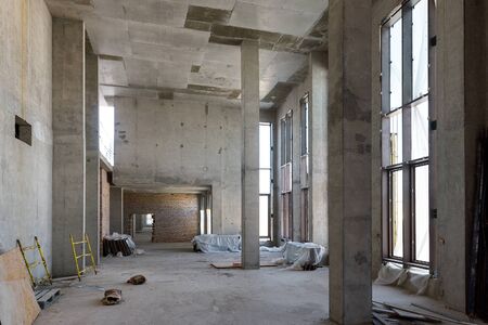 Construction of large building. Inside the modern construction site. Contemporary structure under construction with concrete walls, pillars, ceiling and floor. Concept of building business.の写真素材