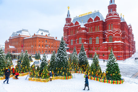 Moscow, Russia - Feb 5, 2018: Snowy Moscow center in winter. Christmas trees on the Manezhnaya square during snowfall. Nice vintage architecture of Moscow under snow. Russian cold and frost concept.のeditorial素材