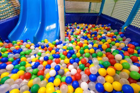 Playground for sport and play in kindergarten. Inside the plastic dry pool with colorful balls and slide. Nice kids gym for activity and development in playroom. Children playground closeup indoor.の写真素材