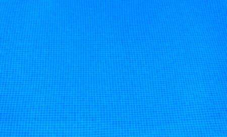 Pool with pure blue water background. Top view of swimming pool and floor texture. Panorama of pool bottom with tile pattern and transparent water. Background for recreation and resort vacation.の写真素材