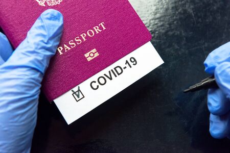 COVID-19 coronavirus pandemic and travel concept, COVID-19 note in passport. Novel corona virus outbreak. Quarantine of tourists infected with coronavirus.の写真素材