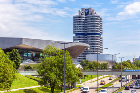 Munich, Germany - Aug 2, 2019: The BMW world headquarters or BMW four-cylinder in Munich, Bavaria. It is famous landmark of city. Urban landscape with road, modern buildings and BMW tower with museum.のeditorial素材