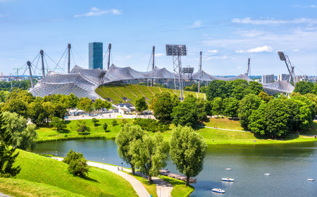 Munich Olympiapark in summer, Germany. Scenic view of  stadium and lake. Panorama of the famous Munich sport area. Cityscape of Munich with beautiful park. Landscape of green European city.のeditorial素材
