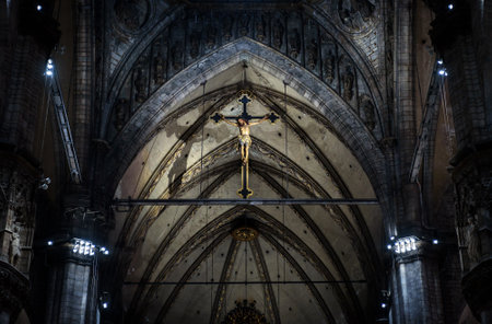 Milan, Italy - May 16, 2017: Statue of crucified Jesus Christ inside Milan Cathedral. Holy cross in interior of dark Catholic church, view of crucifix in altar. Concept of spirit, prayer and worship.のeditorial素材