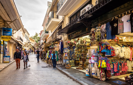 Athens - May 8, 2018: Gift market near Plaka district in Athens, Greece. People visit souvenir stores and walk in Greek bazaar outdoors in city center. Shopping, travel and vacation in old Athens.のeditorial素材