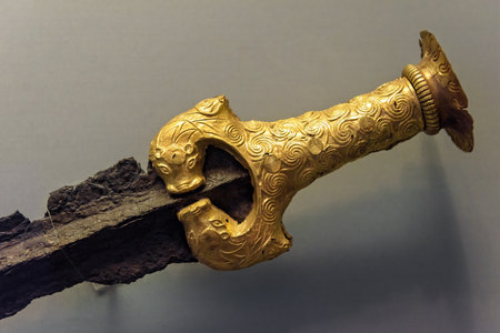 Athens - May 7, 2018: Bronze sword with gold hilt revetment from Greek Mycenae in National Archaeological Museum of Athens, Greece. Golden artifact, jewelry and history of ancient civilization.のeditorial素材