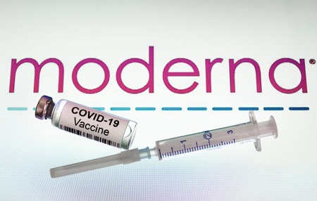 Moscow - Jan 5, 2021: Moderna COVID-19 vaccine. Syringe and bottle with US vaccine for coronavirus on logo background. Concept of corona virus drug, injection and clinical trial during COVID pandemicのeditorial素材
