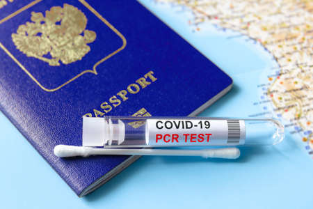 Coronavirus, travel and test concept, tube for COVID-19 PCR testing and passport on tourist map....