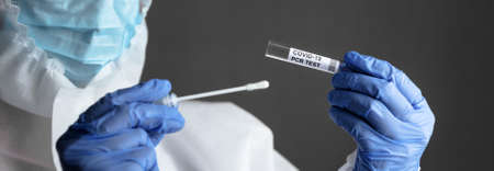 COVID-19 test in doctor hands, nurse in medical personal protective equipment (PPE) holds coronavirus swab collection kit. Concept of corona virus PCR testing, cure and diagnostics during pandemic.の写真素材