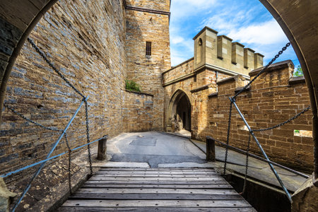 Hohenzollern Castle entrance, Germany, Europe. This castle on mountain top is famous landmark in Stuttgart vicinity, great German monument. Doorway and wooden bridge of strong Gothic castle.のeditorial素材