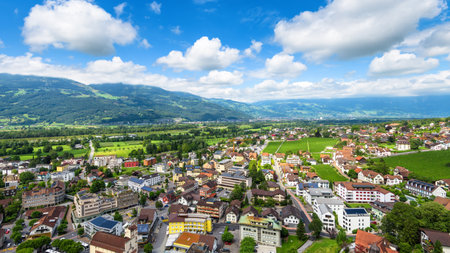 Skyline of Vaduz, principality of Liechtenstein. Scenic aerial view of city in Swiss Alps. Panorama of green valley with town and blue sky in summer. Landscape of Liechtenstein in Alpine mountains.のeditorial素材