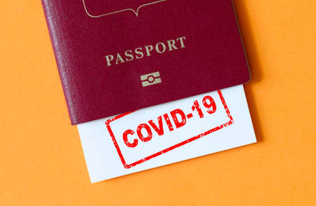 Travel and coronavirus concept, COVID-19 stamp in tourist passport. Medical test at border control due to COVID. Business and tourism hit by corona virus, lockdown and restrictions during pandemic.の写真素材