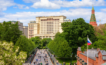 Moscow - June 2, 2021: Scenic view of the Four Seasons Hotel at Moscow Kremlin, Russia. People walk in Alexander Garden, panorama of green park in summer. Concept of travel and tourism in Moscow.のeditorial素材