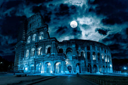 Colosseum at night, Rome, Italy. Mystery creepy view of Ancient Coliseum in full moon. Spooky dark scene with famous landmark in Rome city center in blue light. History, Halloween and horror concept.の写真素材
