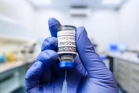 Corona virus vaccine in researcher hand in laboratory, doctor holds COVID-19 vaccine for injection...
