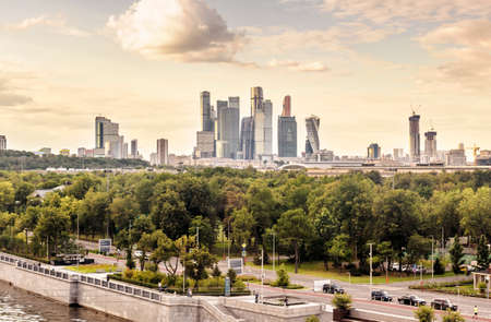 Moscow in summer, Russia. Scenic panorama of Luzhniki Park and Moscow-City tall buildings in distance. Sunny view of Moskva River green embankment, modern Moscow cityscape and skyline.の写真素材
